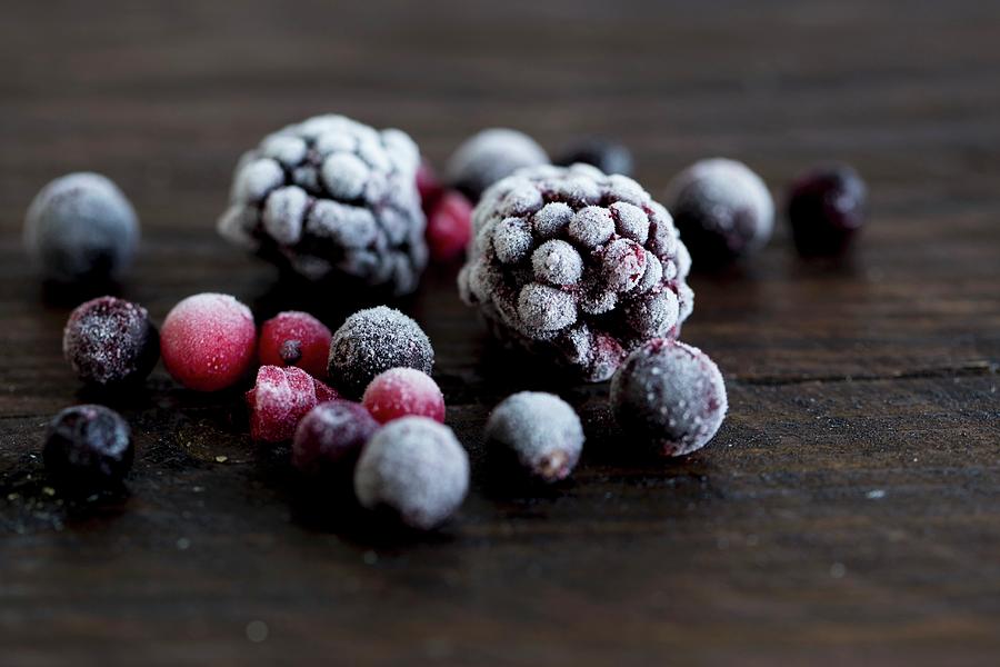 Frozen Forest Berries On A Wooden Surface Photograph by Nicole Godt