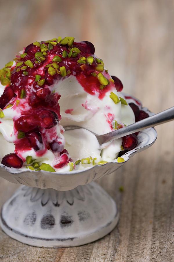 Frozen Yogurt With Chopped Pistachios And Pomegranate Seeds With A Bite Taken Out Photograph by Esther Hildebrandt