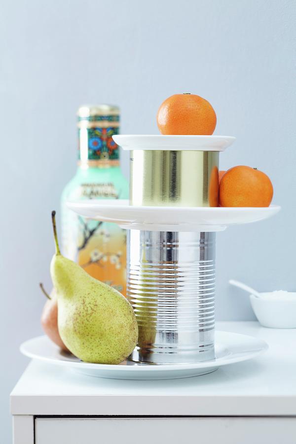Fruit On A Simple Cake Stand Made Of Plates And Tin Cans Photograph by Franziska Taube