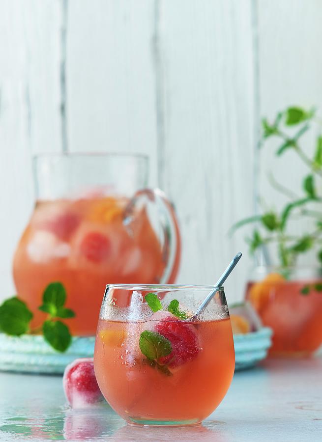 Fruity Summer Punch With Pomegranate Juice, Mineral Water, Mint, Ice Cubes, And Frozen Berries Photograph by Stefan Schulte-ladbeck