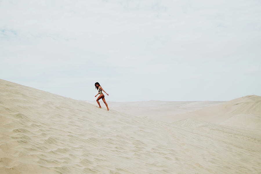 Full Length Of Woman In Swimwear Walking On A Dune, Huacachina,peru ...