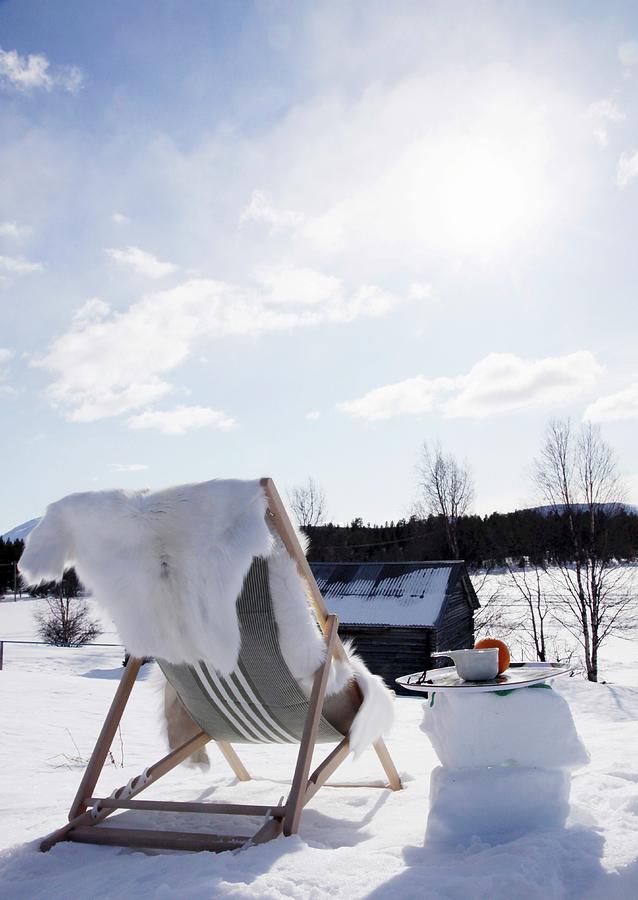 Fur Blanket On Lounger Amongst Snow Under Blue Sky Photograph by Susanna Rosn