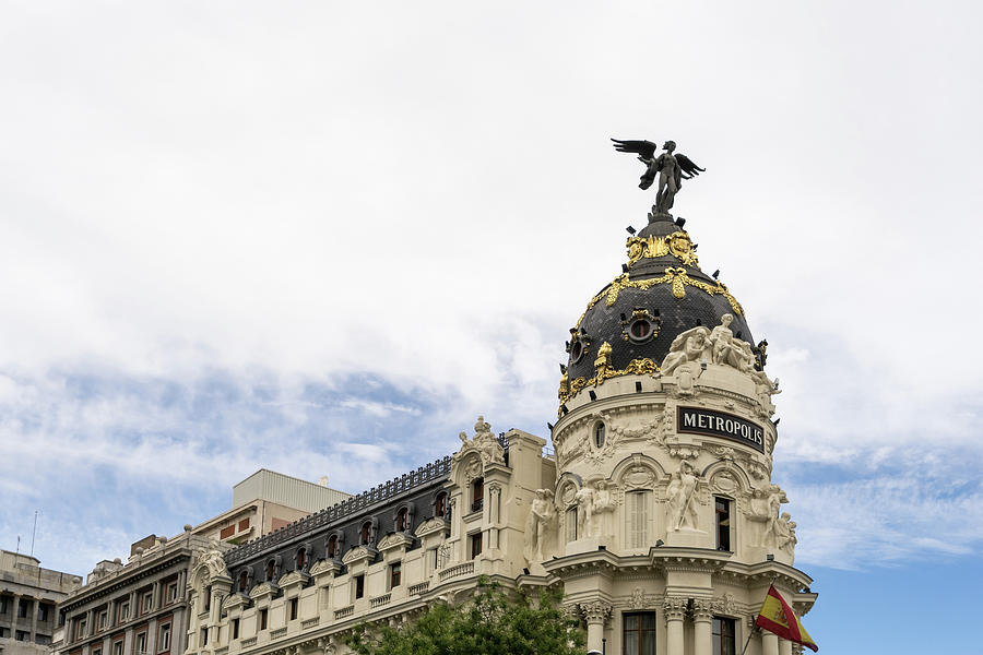 Gallivanting Around Madrid is a Pure Delight - Iconic Metropolis Building with White Clouds Photograph by Georgia Mizuleva