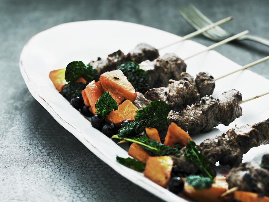 Game Skewers With Spinach And Sweet Potatoes Photograph by Mikkel Adsbl