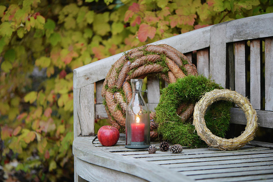 Garden Bench Decorated With Wreaths moss, Fir Cones And Straw And Candle Lantern Photograph by Daniela Behr