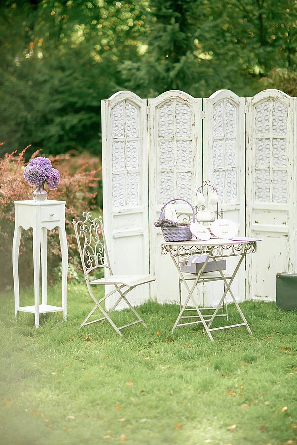 Garden Table, Ornate Metal Chair, Vintage Screen And Vase Of Hydrangeas On Side Table Photograph by Elizaveta Dogadaeva