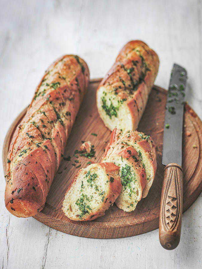 Garlic And Herb Bread Cut On Board With Knife Photograph by Michael Paul