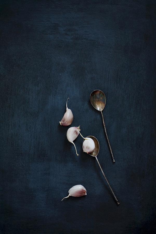 Garlic Cloves And Vintage Silver Spoons On A Black Background Photograph by Alicja Koll