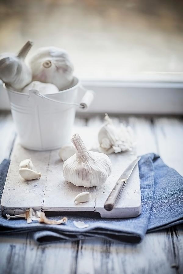 Garlic In A Little Zinc Bucket And On A Wooden Board Photograph by Susan Brooks-dammann
