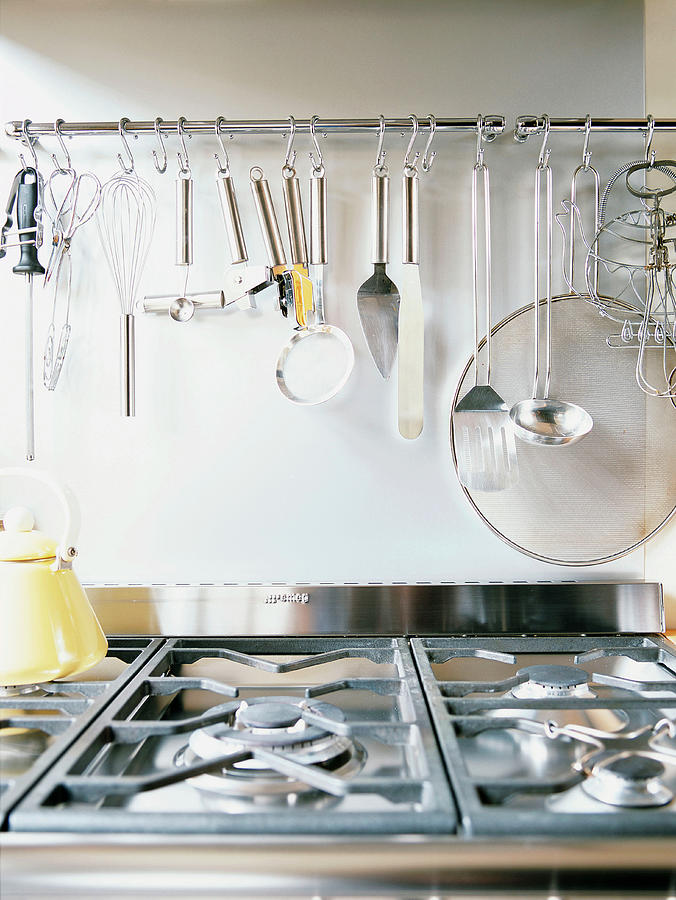 Gas Hob And Kitchen Utensils Hung On Wall Photograph by Luc Wauman