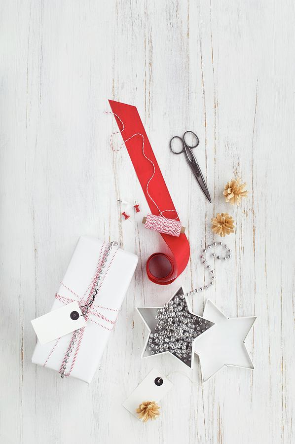 Gift Wrapped In Red And White And Wrapping Materials Photograph by Achim Sass