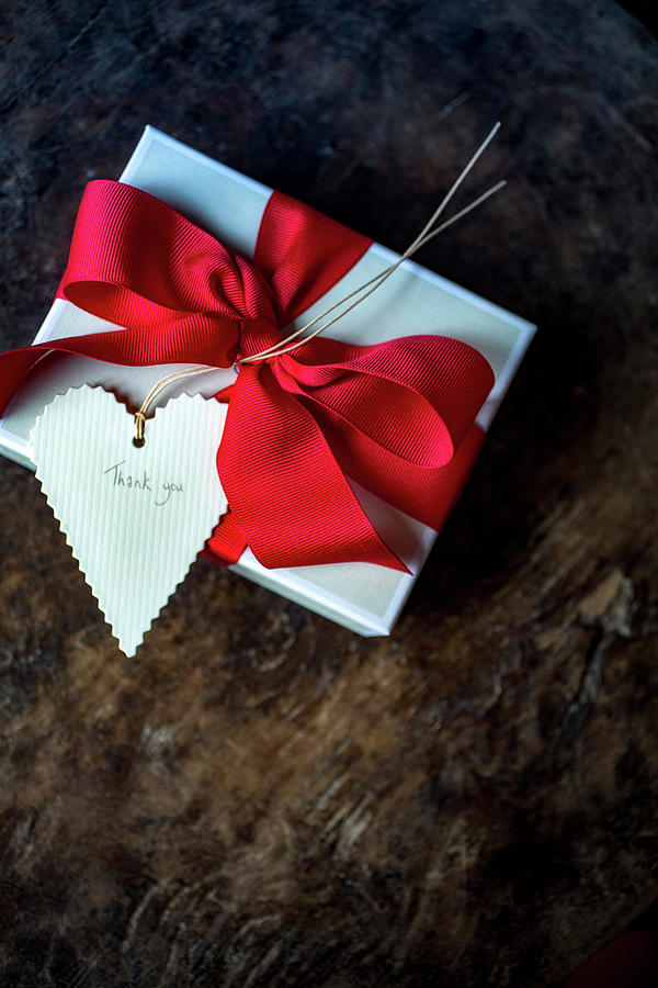 Gift Wrapped With Red Bow And thank You Written On Heart-shaped Tag Photograph by Eising Studio