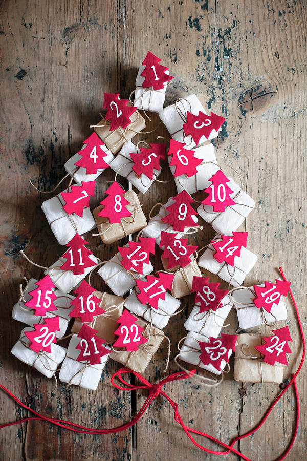 Gifts With Numbered, Red Felt Christmas Trees Arranged In Tree Shape Photograph by Alicja Koll