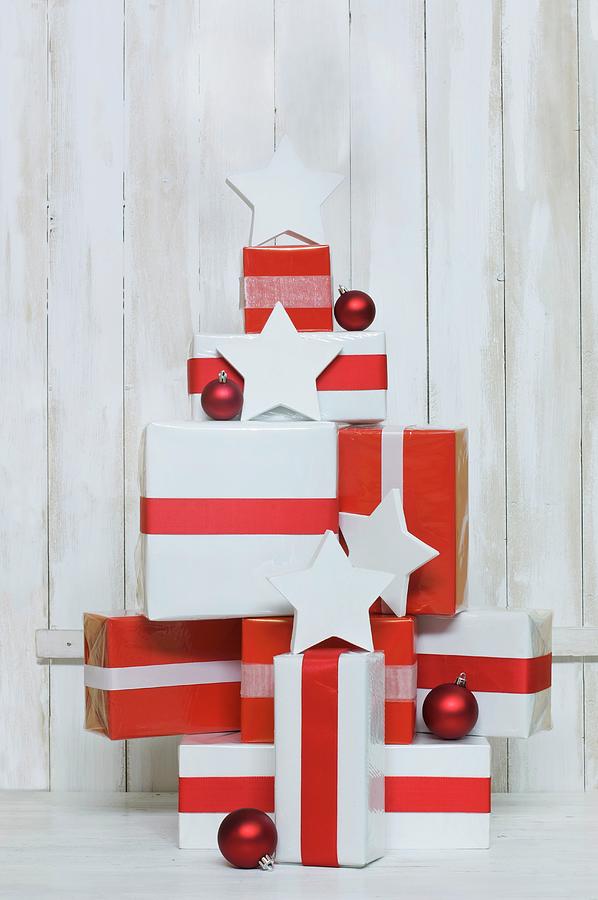 Gifts Wrapped In Red And White Stacked In Shape Of Christmas Tree Photograph by Achim Sass