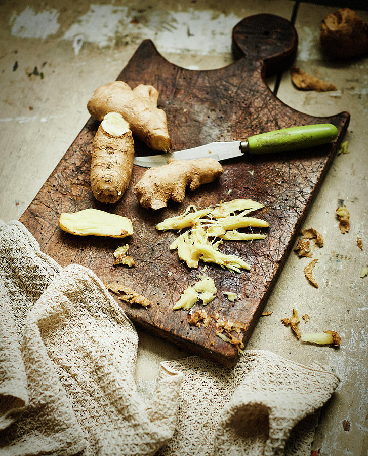 Ginger Root And Sliced Ginger On Rustic Wooden Board Photograph by Catherine Gratwicke