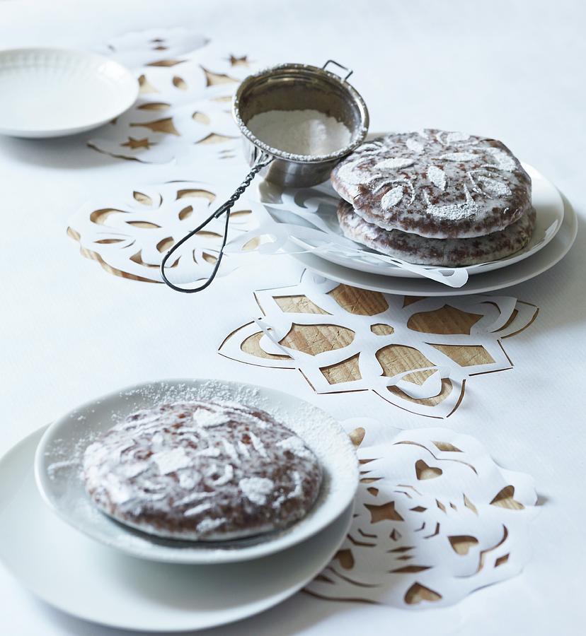 Gingerbread Decorated With Icing Sugar On White Tablecloth With Cut-out Patterns Photograph by Andreas Hoernisch
