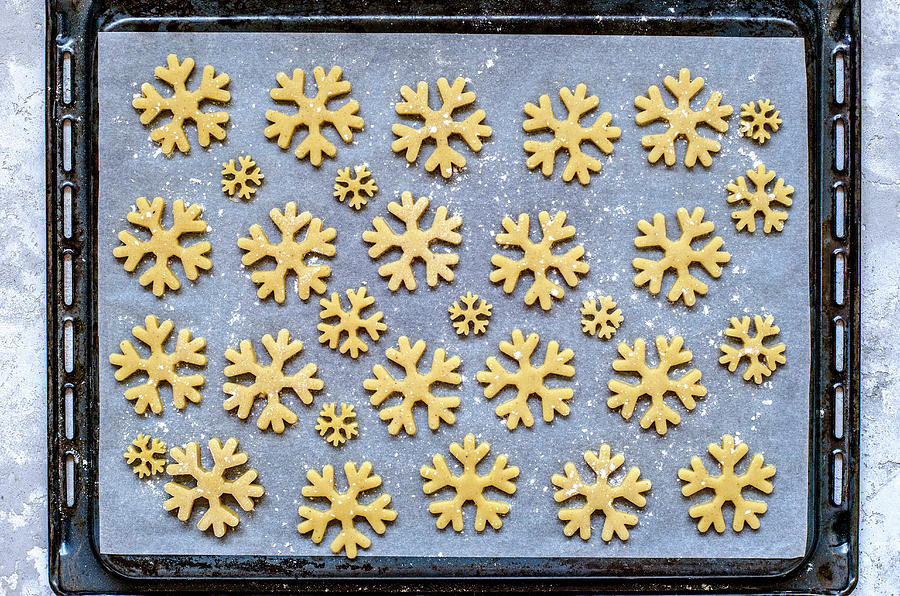 Gingerbread Dough Cut In The Form Of Snowflakes On Parchment And Deco Before Baking Photograph by Gorobina
