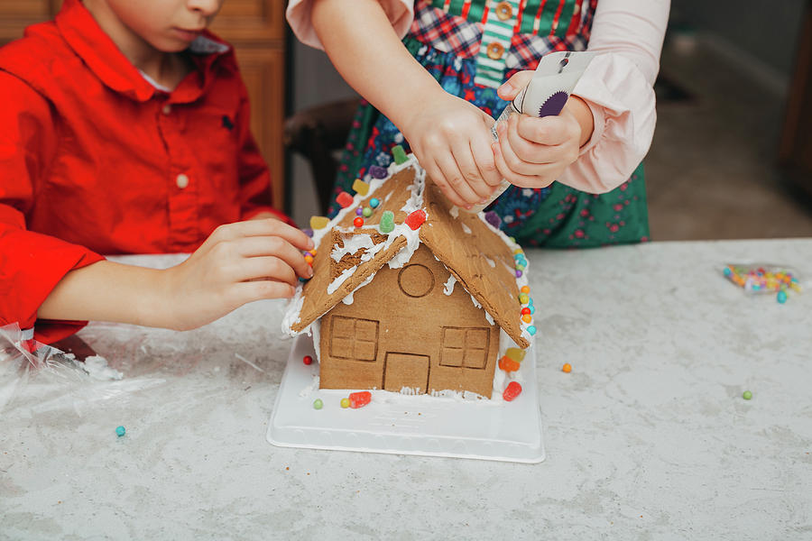 Christmas Photograph - Gingerbread House Decorating Kids At Christmas by Cavan Images