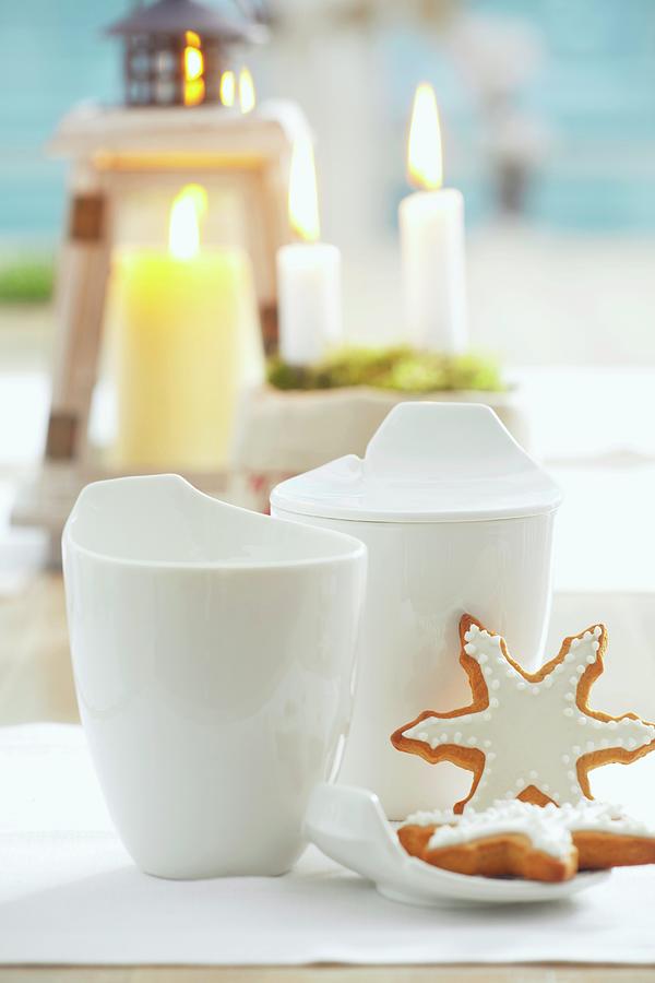 Gingerbread Stars With White Icing And White Cups In Front Of Candles Photograph by Studio Lipov