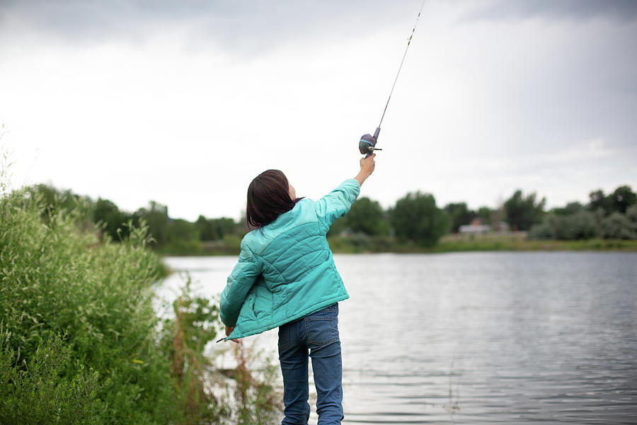 Girl Casting Fishing Line Over Her Head by Cavan Images