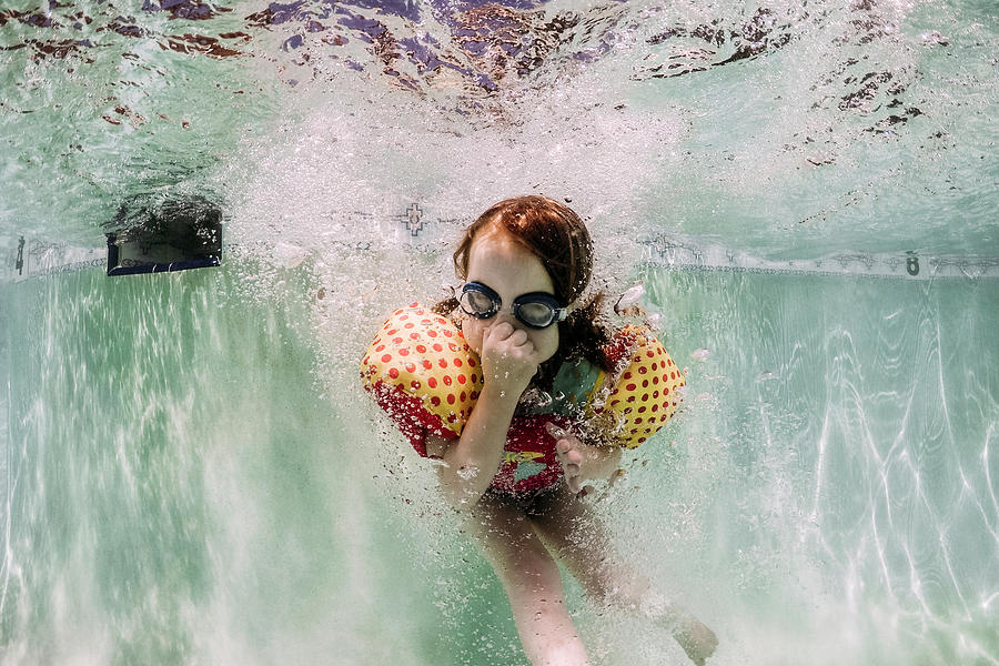 Girl Closing Nose Wearing Goggles And Water Wings While Swimming In Pool Photograph By Cavan