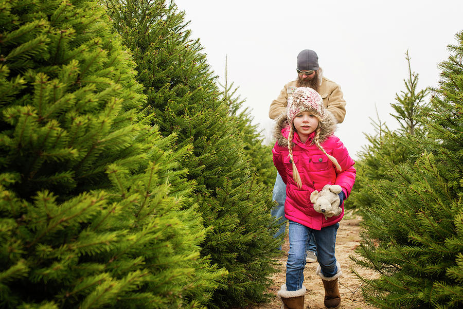 Girl Holding Stuffed Toy Walking With Father Amidst Plants Photograph ...