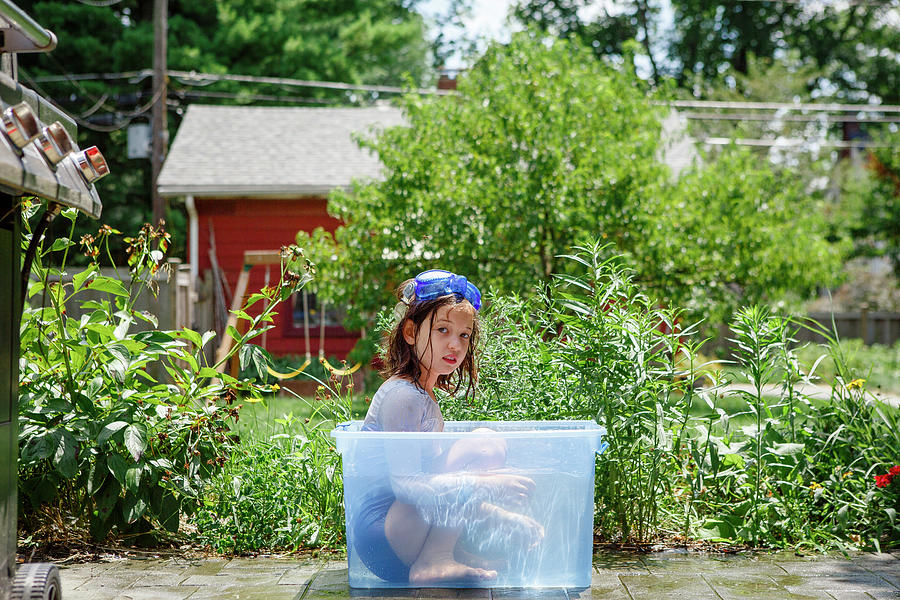 Goggle Photograph - Girl In Bathing Suit And Goggles Sits In Tub Of Water In Garden by Cavan Images