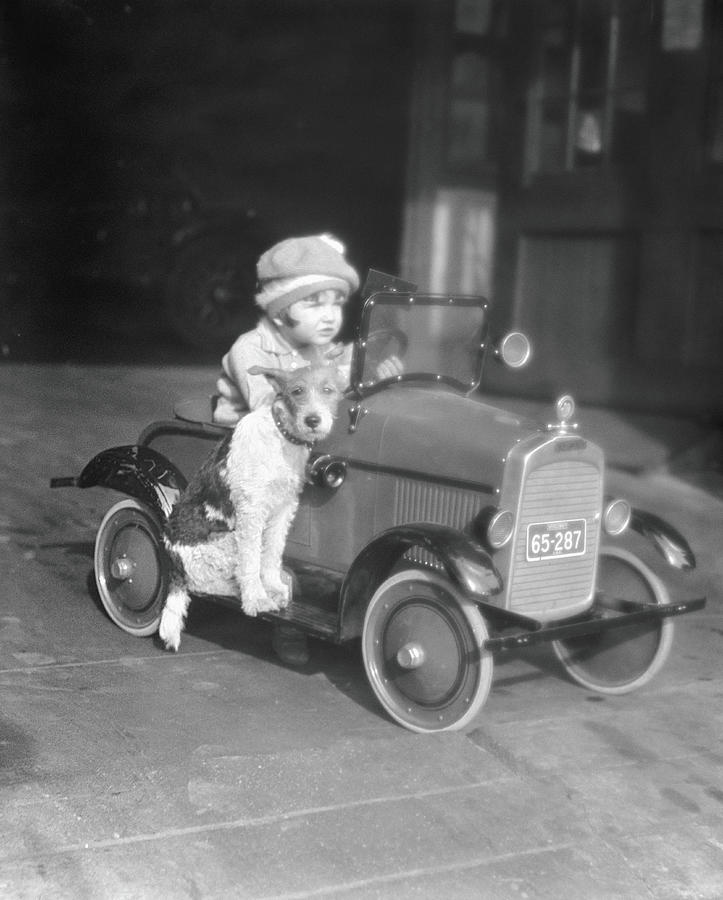 Girl In Toy Pedal Car With Dog Sitting Photograph by H. Armstrong Roberts