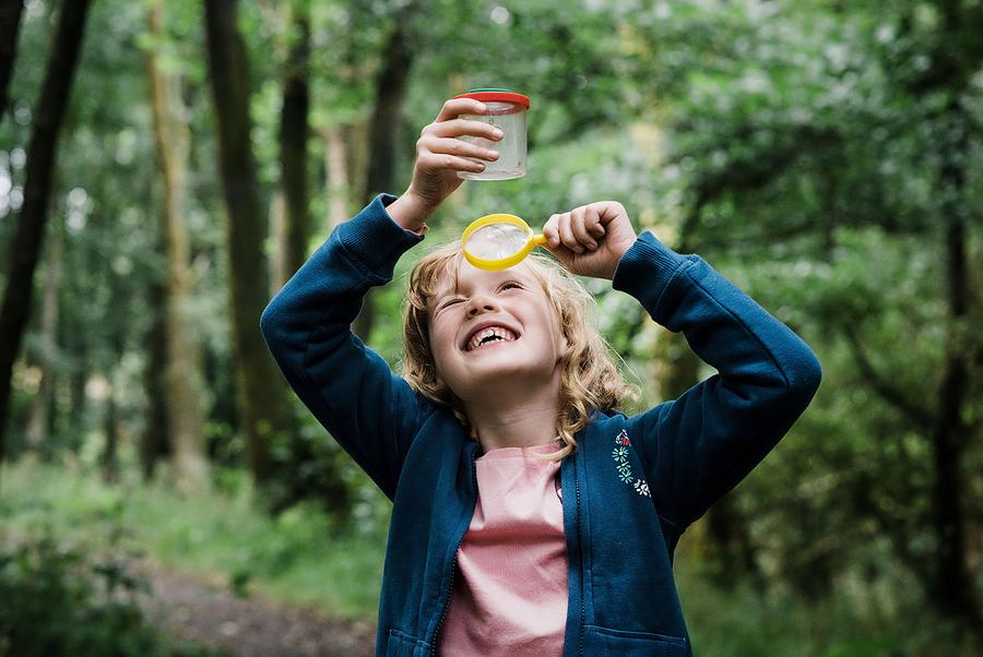 Summer Photograph - Girl Looking Through A Magnifying Glass At Bugs In The Forest by Cavan Images