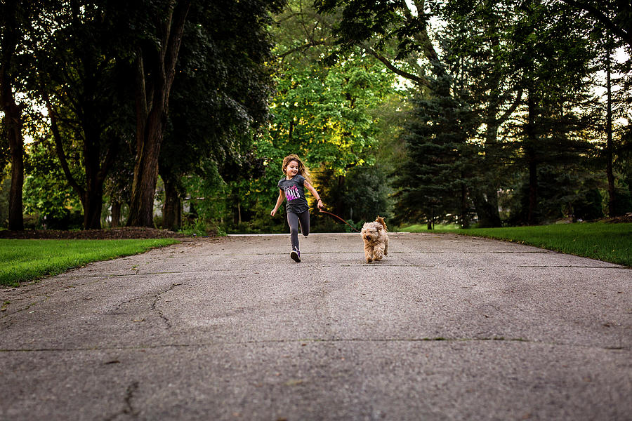Girl Running With Dog On Leash Photograph by Cavan Images - Fine Art ...