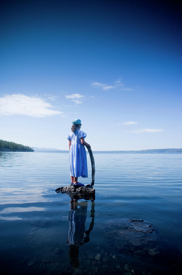 Girl Standing On Rock In Glassy Lake Photograph by Stephen Simpson