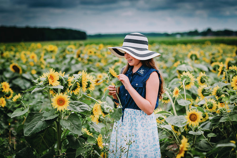 https://images.fineartamerica.com/images/artworkimages/mediumlarge/2/girl-wearing-a-stiped-straw-hat-standing-in-sunflower-field-in-ohio-cavan-images.jpg