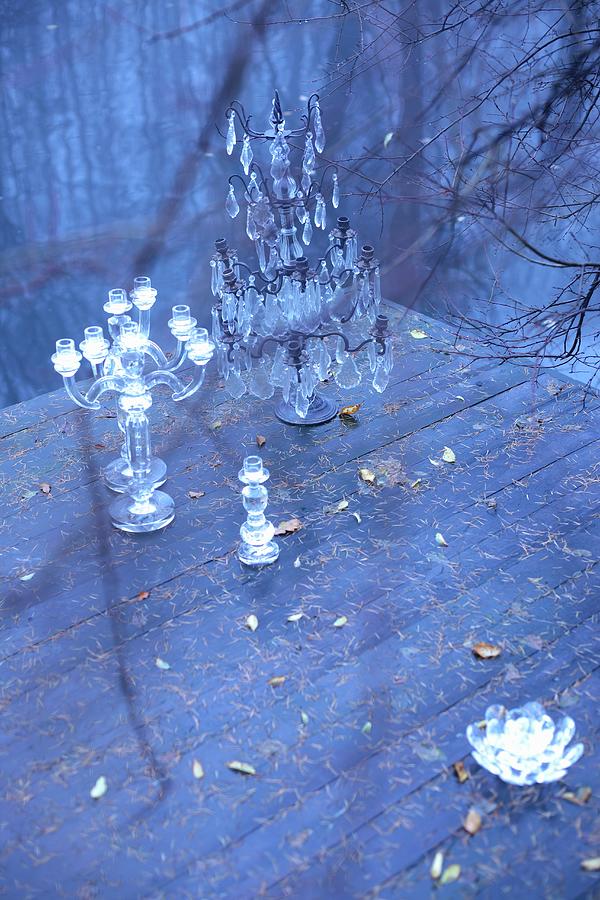 Glass Candlesticks Of Various Sizes And Metal Candelabra With Crystal Pendants On Wooden Deck Next To Lake Photograph by Michal Mrowiec