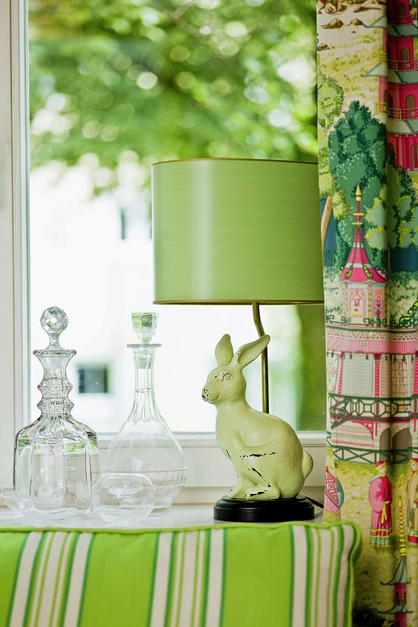 Glass Carafes And Green Retro Lamp With Rabbit Figurine As Base On Windowsill Photograph by Pics On-line / June Tuesday