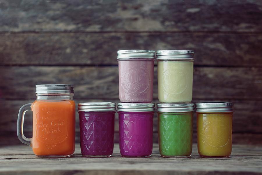 Glass Jars Of Different Coloured Smoothies Photograph by Jan Wischnewski