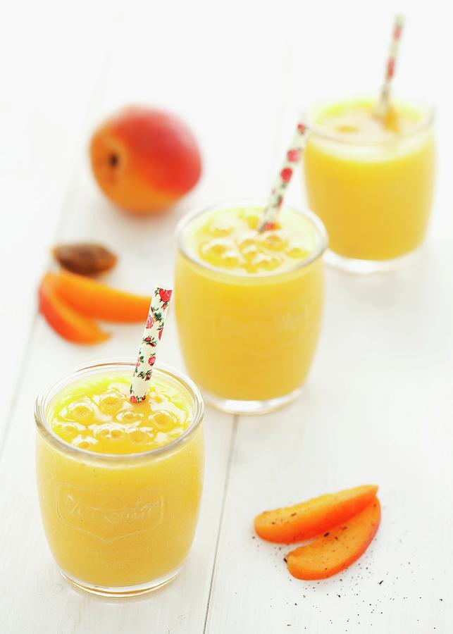 Glasses Of Apricot And Mango Smoothies Photograph by Jane Saunders