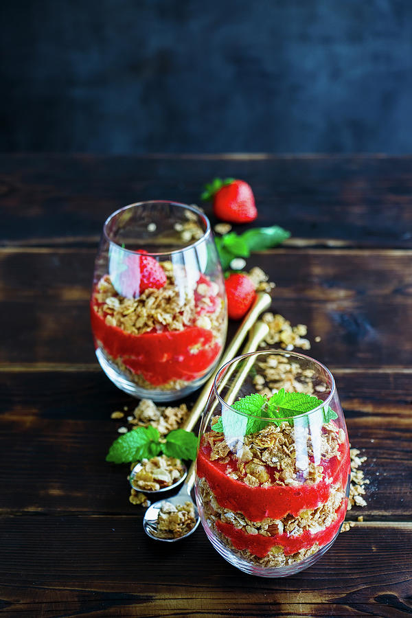 Glasses Of Granola And Strawberries Layered Parfait With Mint For Healthy Breakfast Photograph by Yuliya Gontar