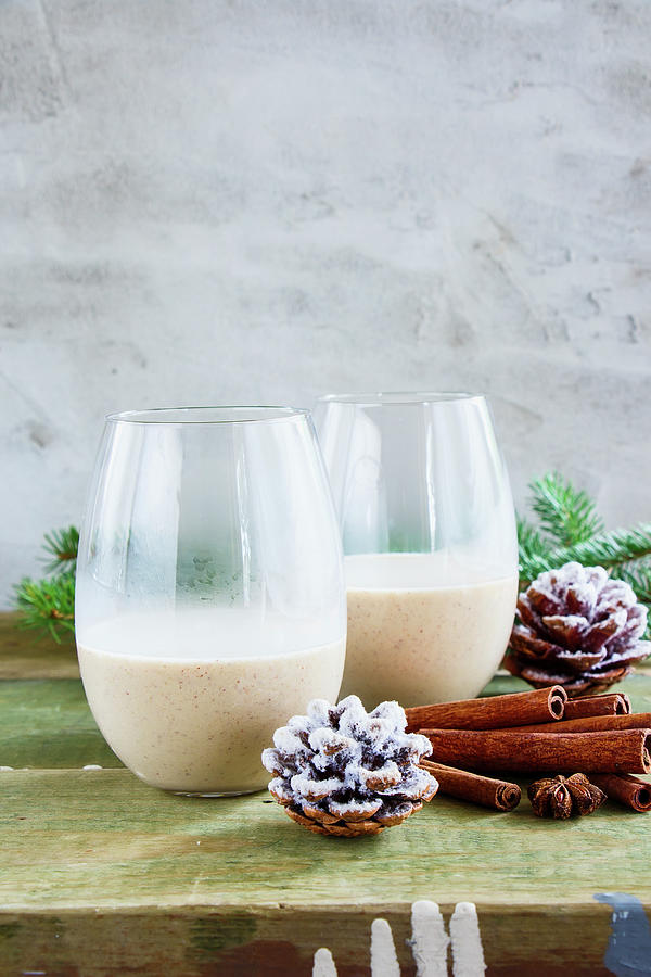 Glasses Of Traditional Winter Eggnog With Milk, Rum And Cinnamon, Christmas Decorations On Wooden Table Photograph by Yuliya Gontar