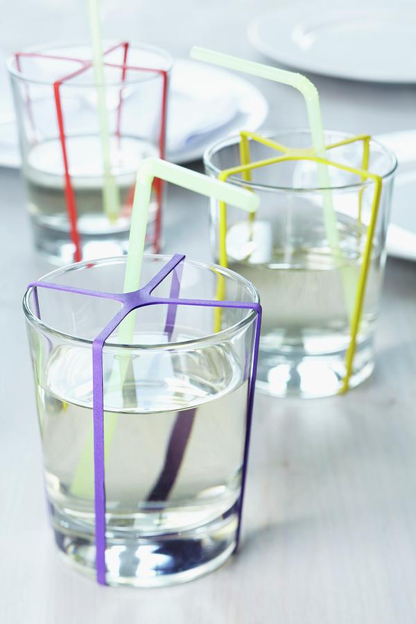 Glasses Of Water Decorated With Colourful Rubber Bands Photograph by Franziska Taube