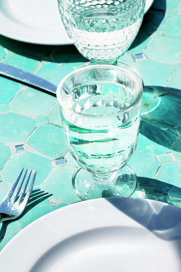 Glasses Of Water On Plates On A Tiled Floor Photograph by Petr Gross
