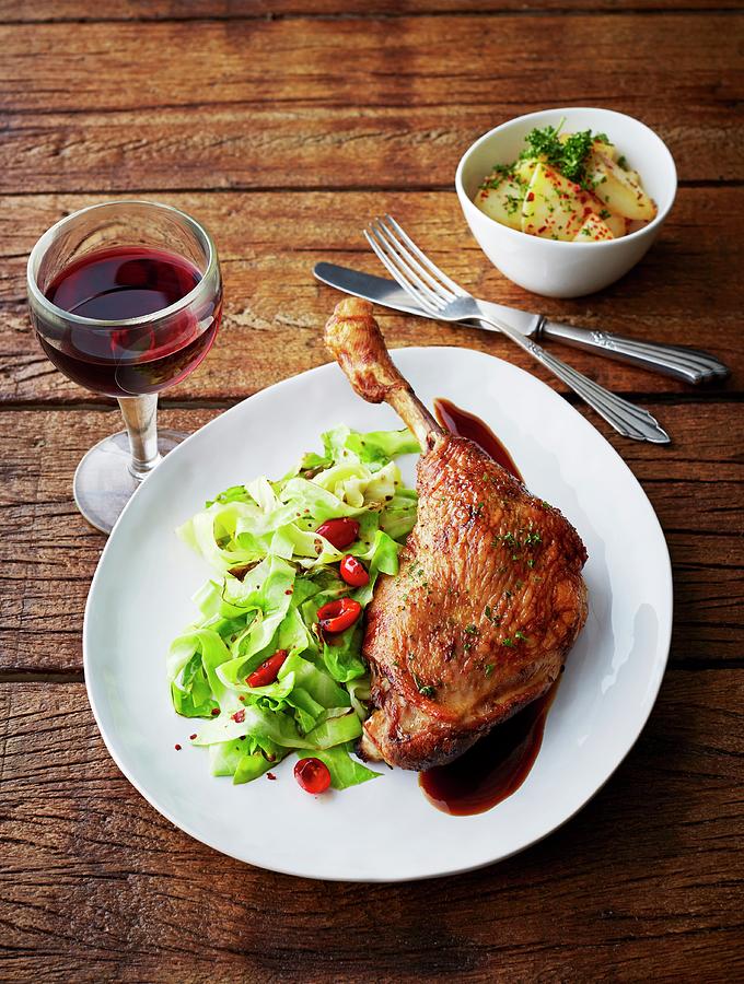 Glazed Goose Leg With Pointed Cabbage, Chilli Pepper, Rose Hip Sauce And A Side Of Potatoes Photograph by Kai Schwabe