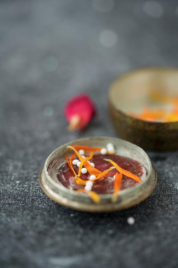 Globules In The Lid Of An Old Pill Tin With Dried Marigold Petals And A Dried Rose Petal Photograph by Mandy Reschke