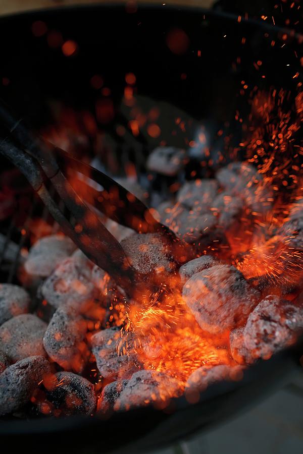 Glowing Charcoal Being Stirred On A Barbecue Photograph by Jalag / Markus Bassler