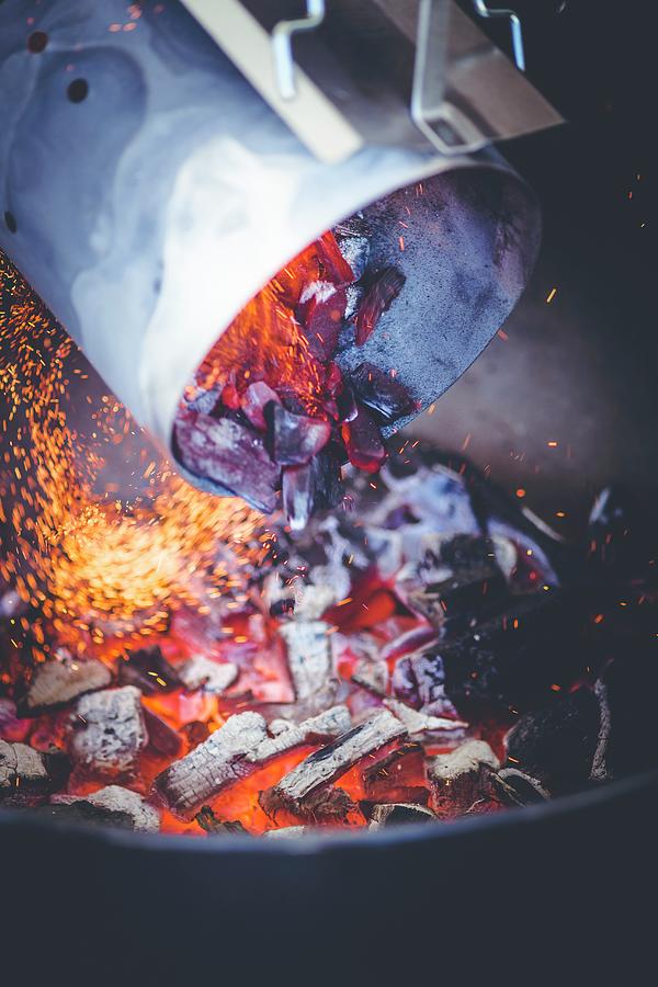 Glowing Charcoal From A Chimney Starter Being Poured Into A Barbecue Photograph by Eising Studio