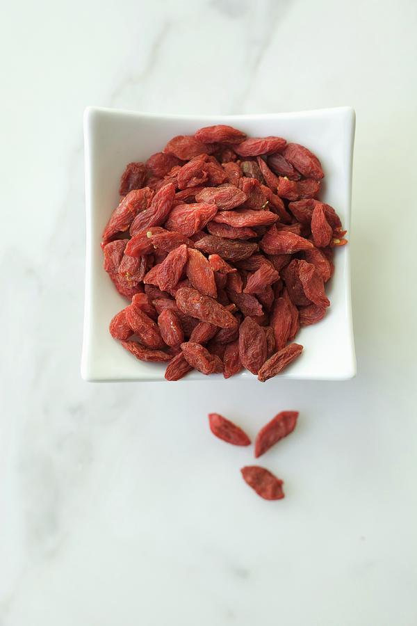 Goji Berries In A White Bowl On A Marble Background Photograph by Andre Baranowski