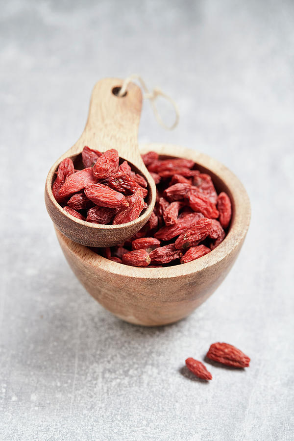 Goji Berries In A Wooden Bowl And A Wooden Scoop Photograph by Brigitte Sporrer