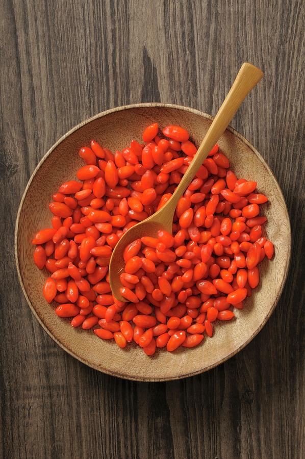 Goji Berries In A Wooden Bowl With A Spoon Photograph by Jean-christophe Riou