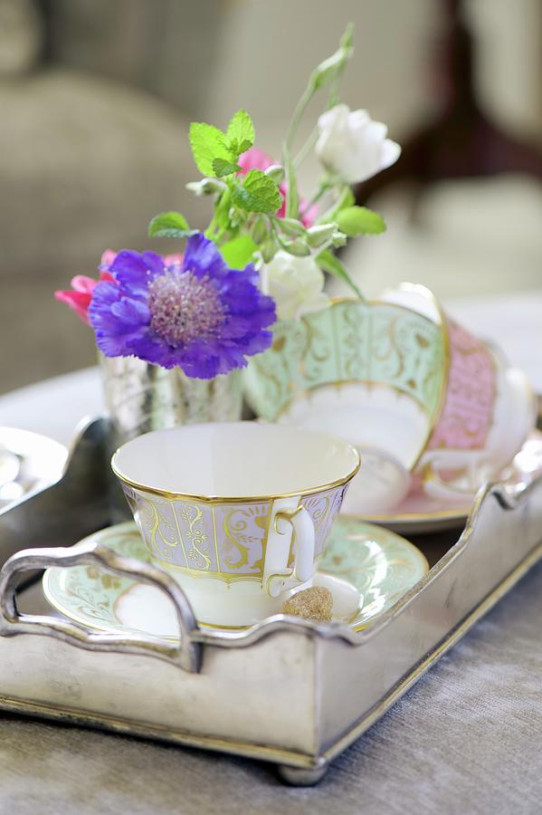 Gold-rimmed Cups And Delicate Flowers On Vintage-style Silver Tray Photograph by Winfried Heinze