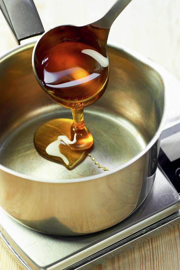 Golden Syrup Being Poured Into A Pot Photograph by Jonathan Short