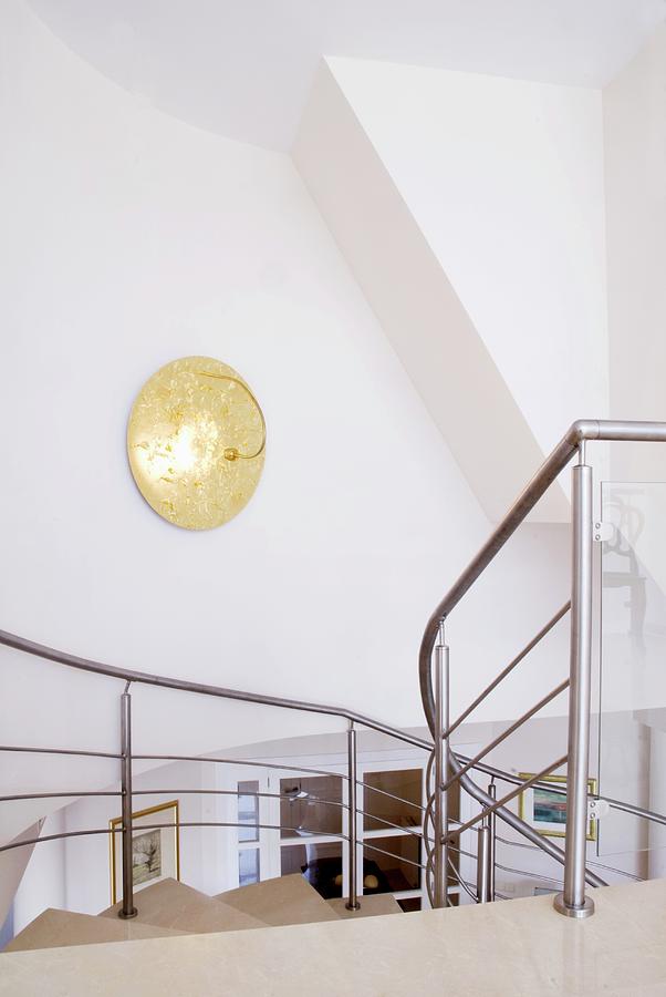 Golden Wall Lamp On Stairwell Wall And View Down Staircase With Stainless Steel Balustrade Photograph by Blickpunkte